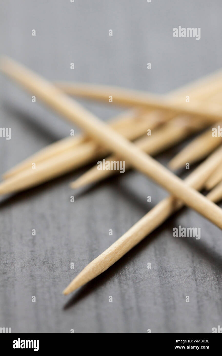 Pile of wooden toothpicks scattered randomly on a grey background for ...