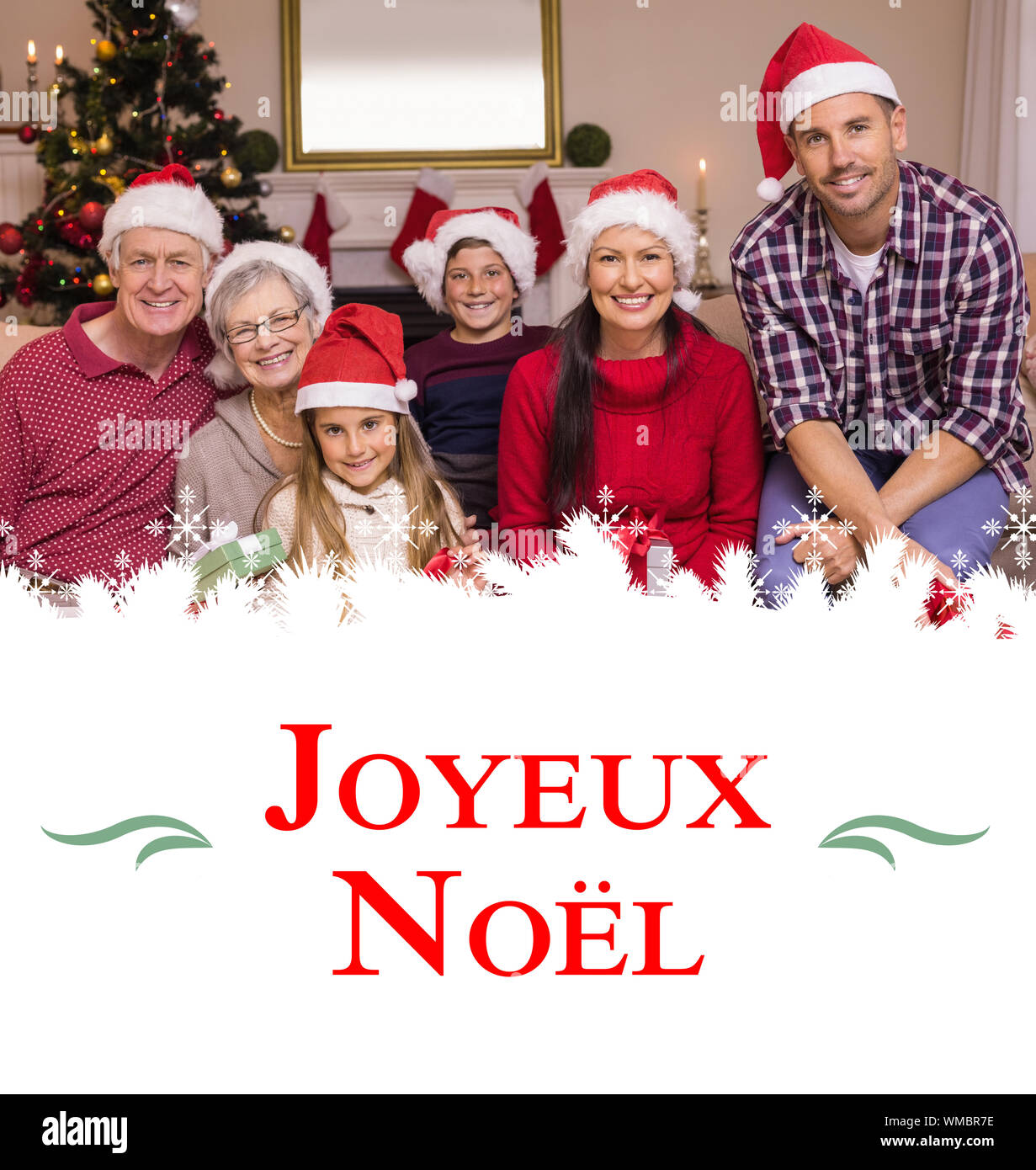 Multigeneration family wearing santa hats on the couch against Christmas greeting card Stock Photo