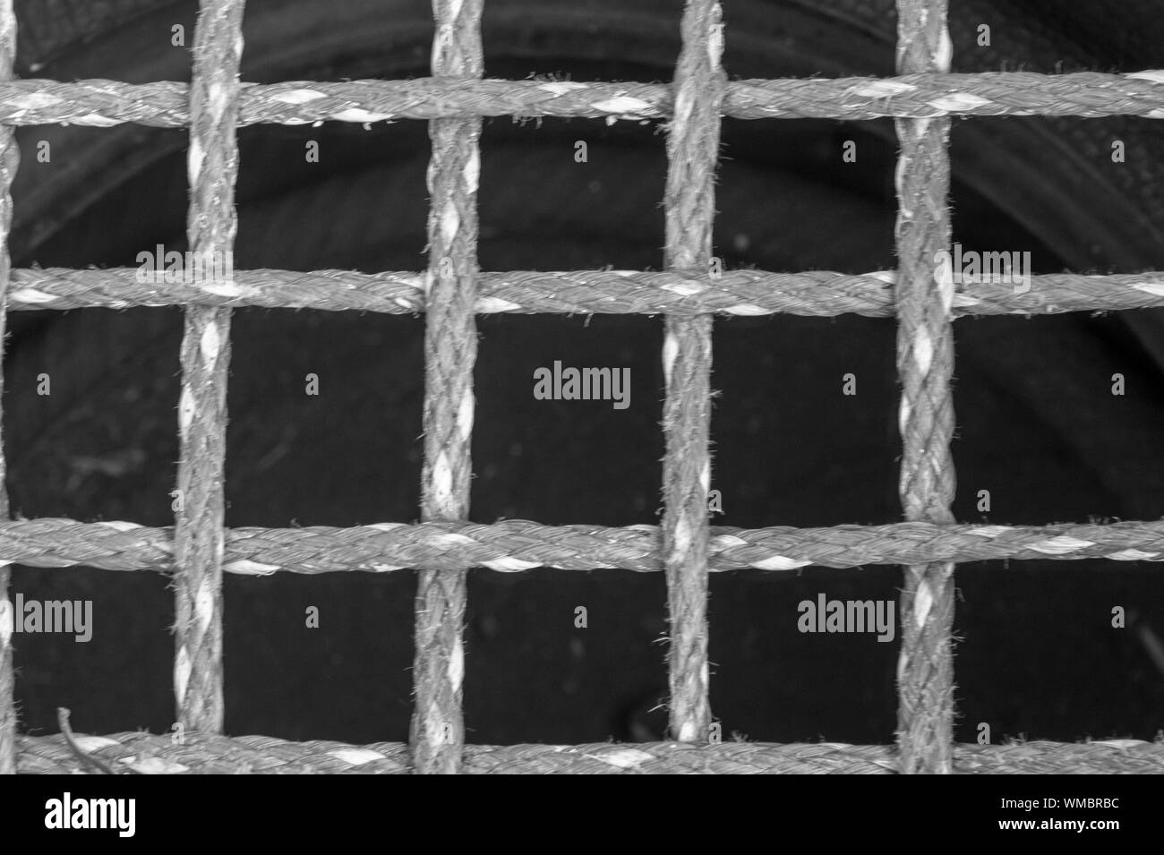 Black and White image of close up of nylon safety netting in an entertainment area to protect children. Lovely textures with speckled contrast. Stock Photo