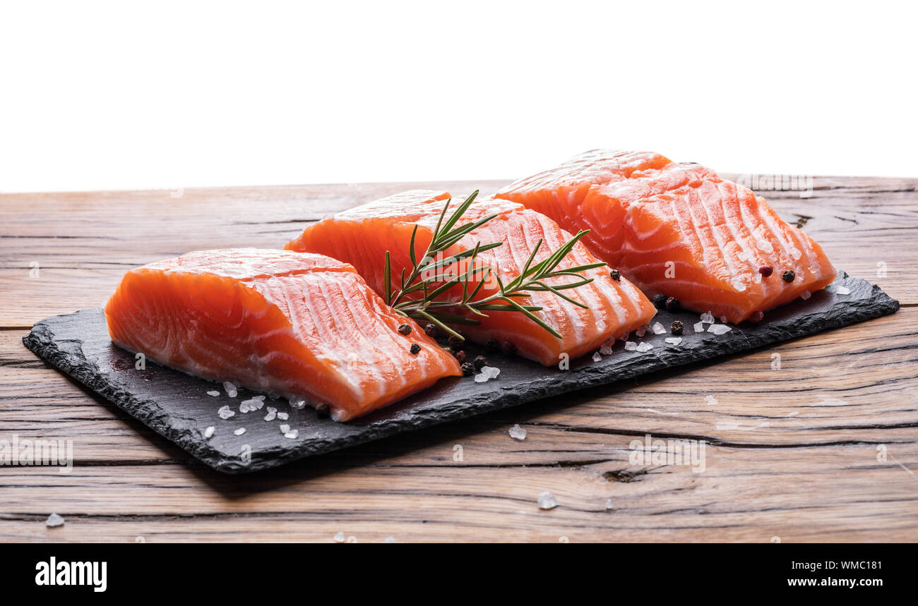 Fresh salmon fillets on black cutting board with herbs and spices Stock ...