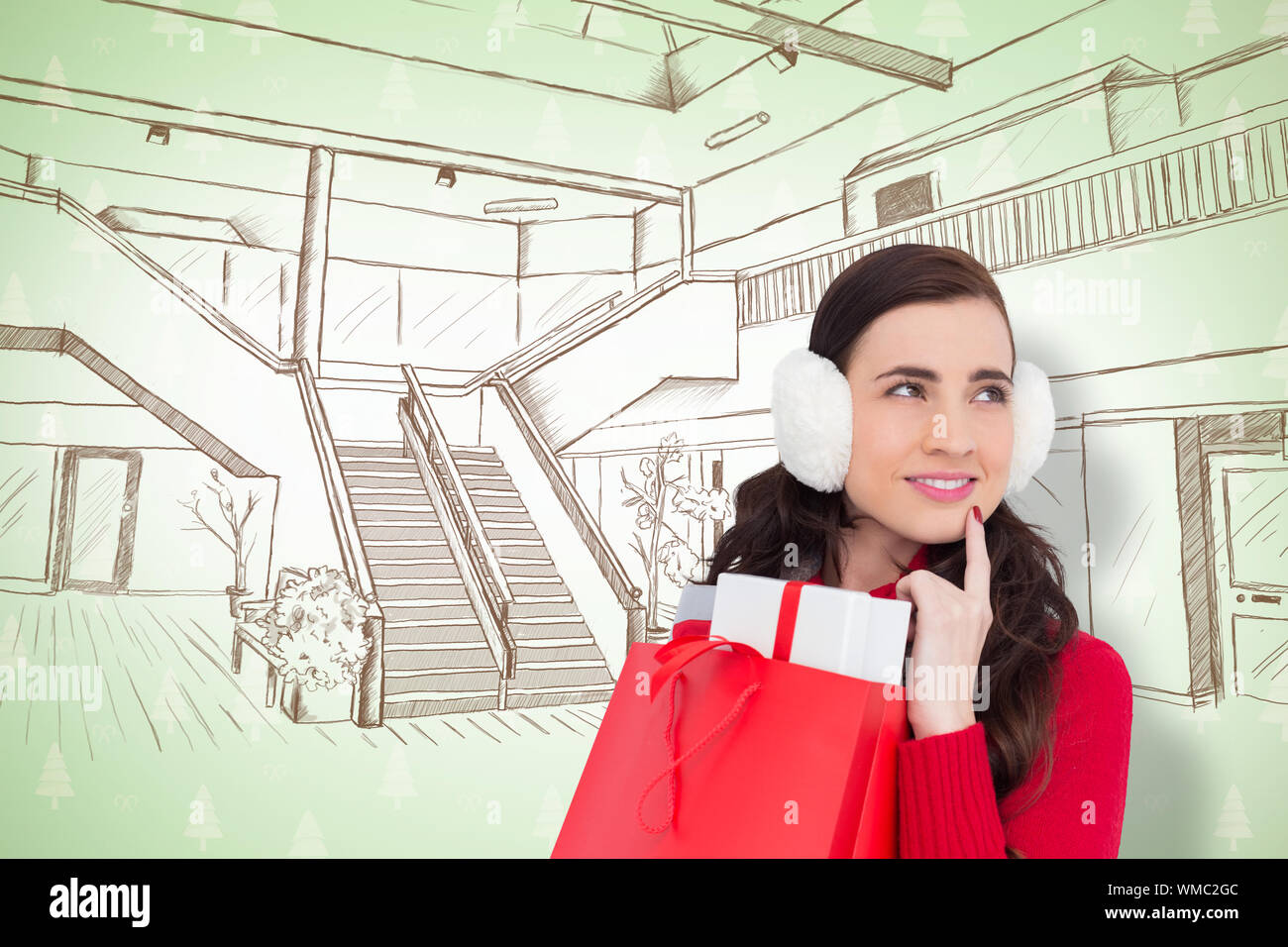Brunette with ear muffs holding shopping bag full of gifts against ...