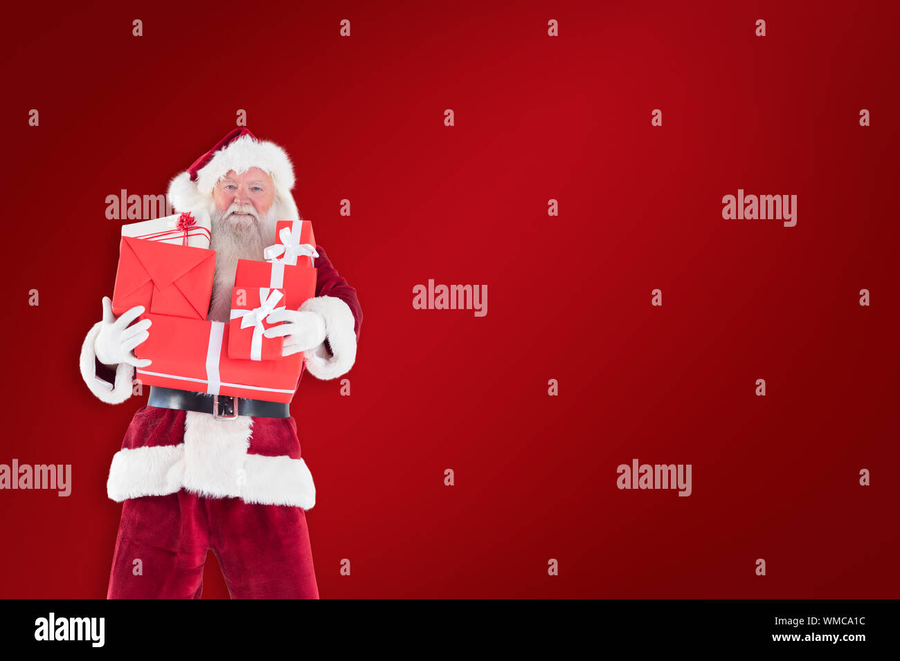 Santa carries a few presents against red background Stock Photo - Alamy