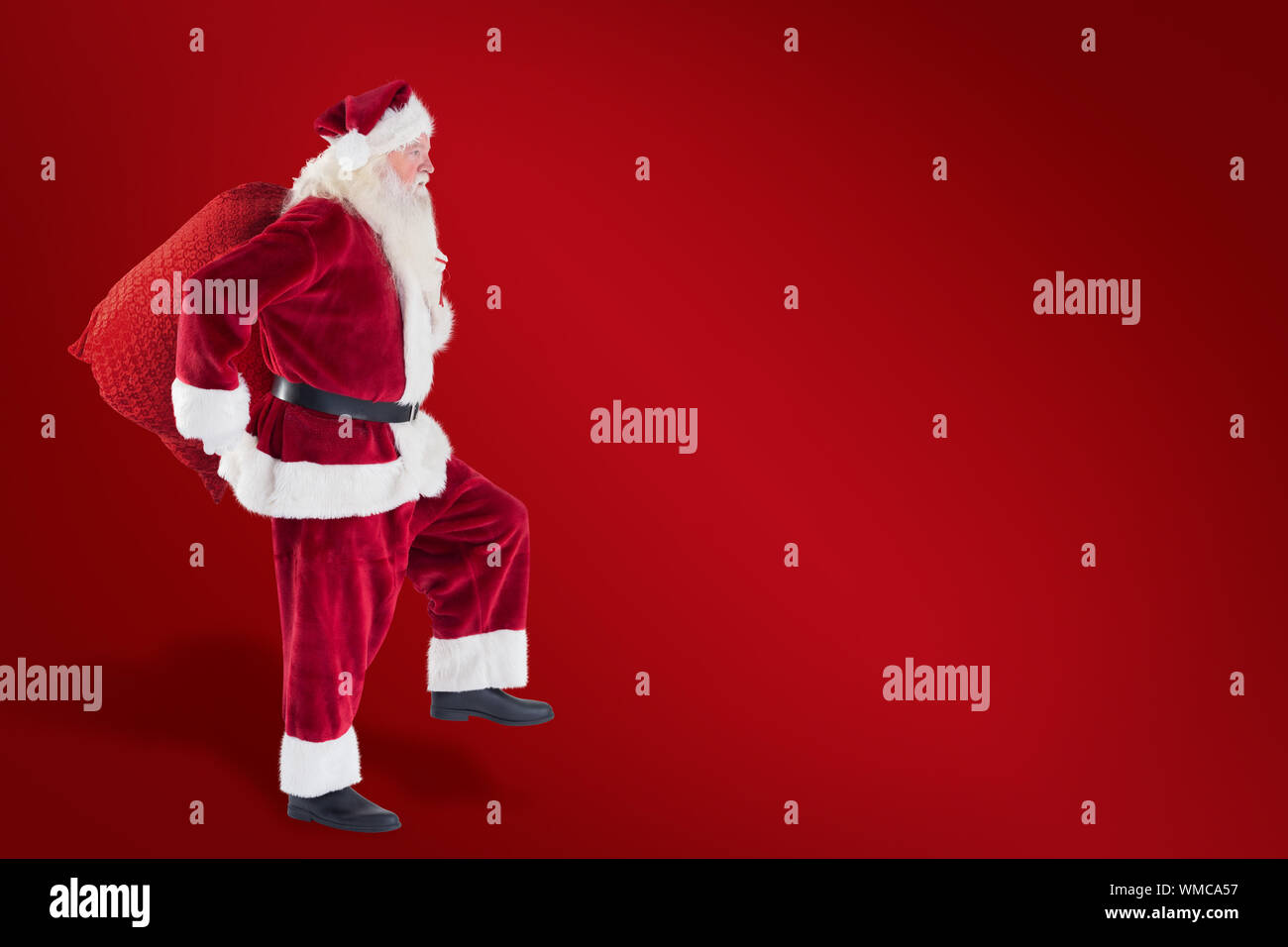 Santa jumps with his bag against red background Stock Photo - Alamy