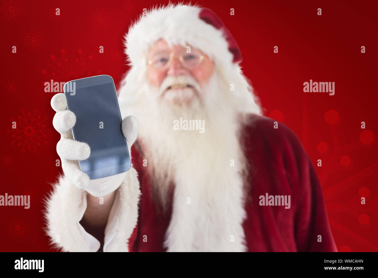Santa Claus shows a smartphone against red background Stock Photo - Alamy