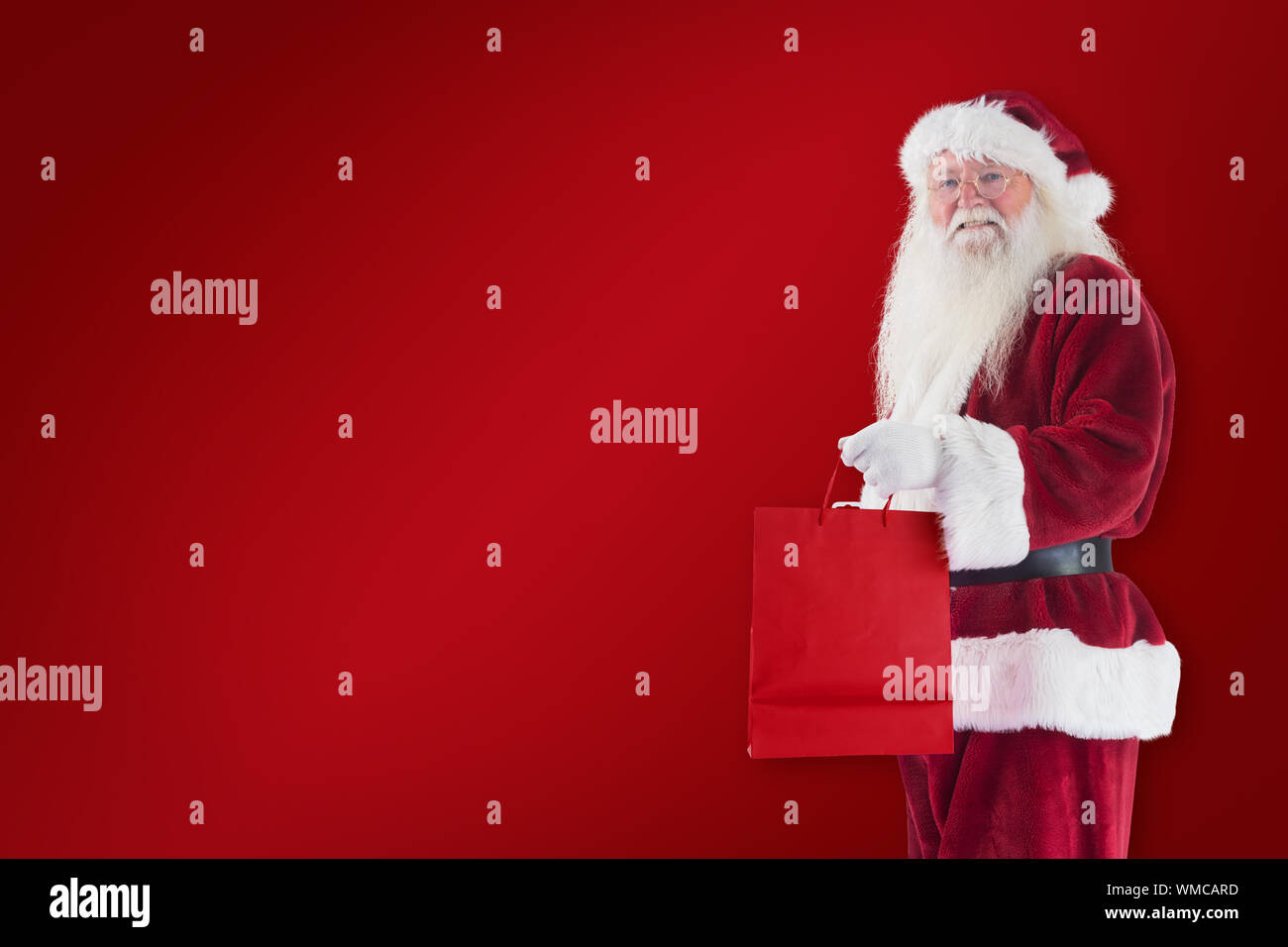 Santa carries red gift bag against red background Stock Photo - Alamy