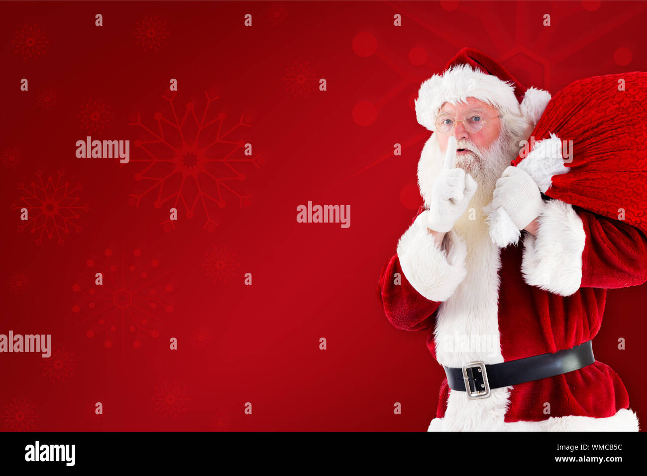 Santa claus carrying sack against red background Stock Photo - Alamy