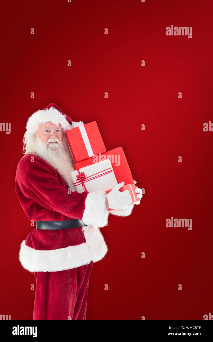 Santa carries a few presents against red background Stock Photo - Alamy