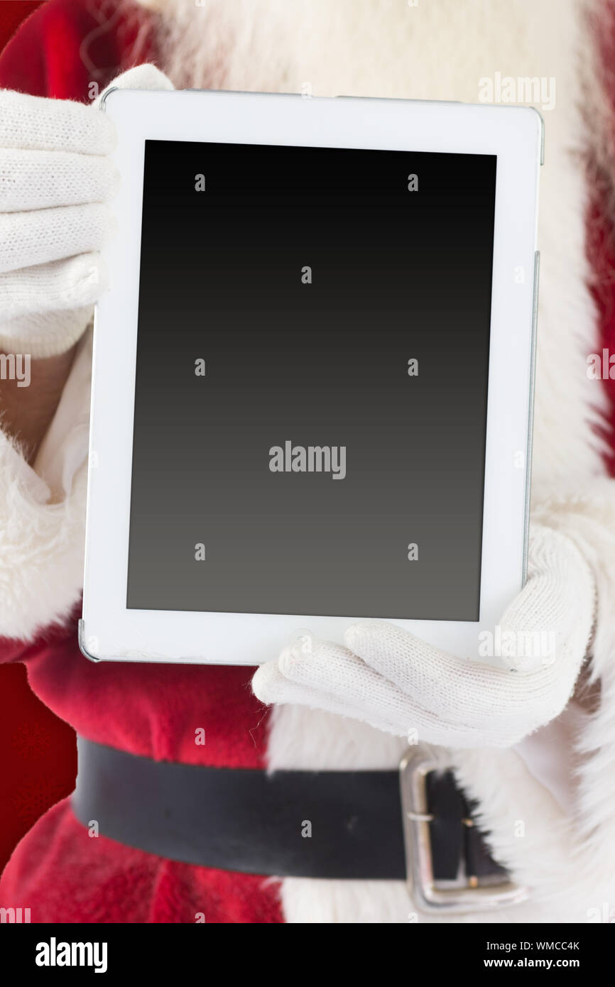 Santa claus showing tablet pc against red background Stock Photo - Alamy