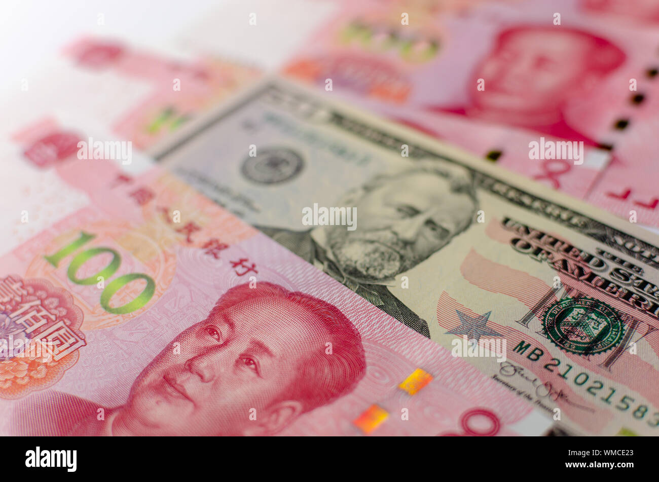 Chinese 100 Yuan banknotes and American 50 dollar bill between them. Close up image of currency of China and United States. Stock Photo