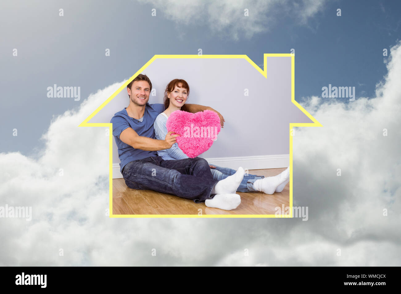 Couple holding a large heart against bright blue sky with clouds Stock ...