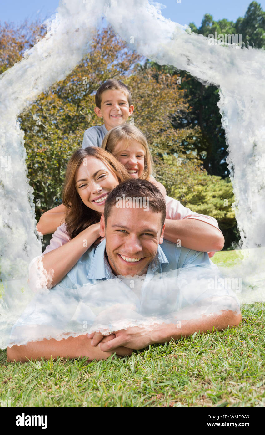 Family members lying on each other against house outline in clouds Stock Photo