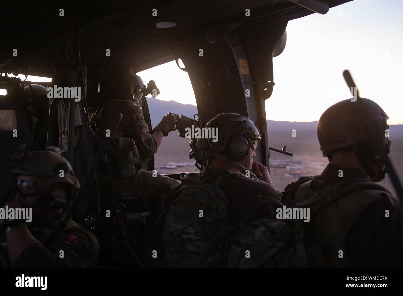 The door gunner of a UH-60 Blackhawk helicopter fires his M240H at targets of interest during a training event near Nellis Air Force Base, Nev. Aug. 26, 2019. U.S. Special Forces utilized the UH-60 Blackhawk helicopter for infiltration and exfiltration purposes while conducting training with U.S. Air Force Joint Terminal Attack Controllers. (U.S. Army photo by Sgt. Steven Lewis)  (U.S. Army photo by Sgt. Steven Lewis) Stock Photo