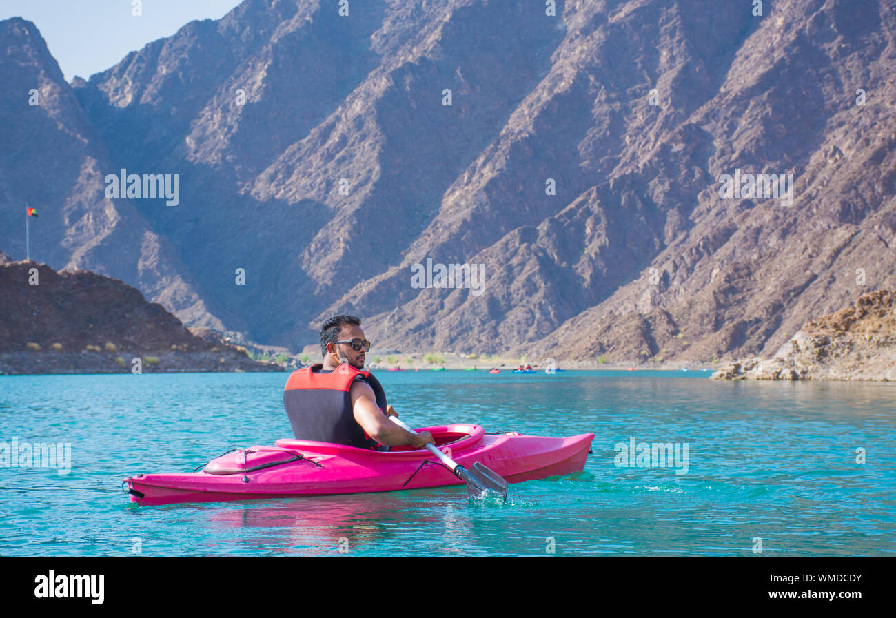 Young man kayaking in Hatta Dam beautiful place for Water Adventure Activities famous tourist attraction of United Arab Emirates Stock Photo