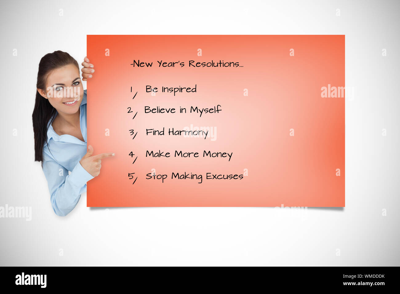 Smiling businesswoman looking around the corner while pointing against orange card Stock Photo ...