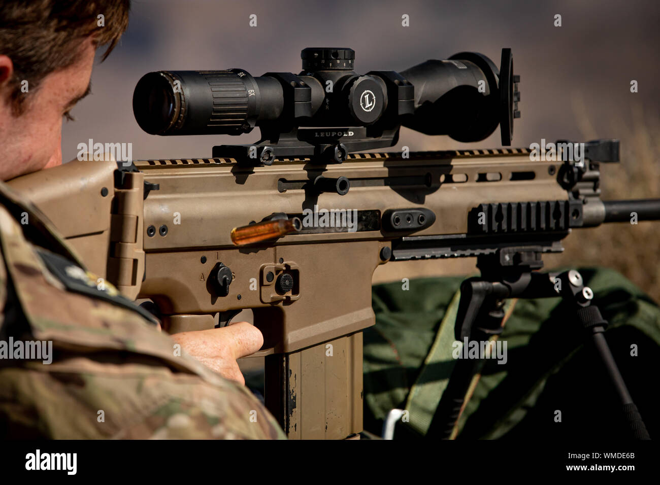 A Green Beret assigned to 3rd Special Forces Group (Airborne) fires the MK17 SCAR-H rifle at a 550-meter target during a training event near Nellis Air Force Base, Nev., Aug. 23, 2019. The shooter uses data from the spotter within the sniper team to make accurate adjustments, allowing the team to effectively engage distant targets. (U.S. Army photo by Sgt. Steven Lewis) Stock Photo