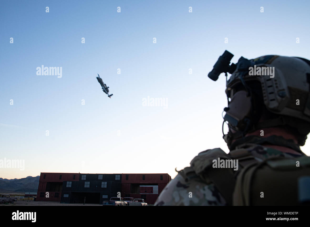 A Green Beret assigned to 3rd Special Forces Group (Airborne) observes an A-10 Thunderbolt ll flying overhead after successfully eliminating a target during a training event near Nellis Air Force Base, Nev. Aug. 26, 2019. U.S. Special Forces trained with U.S. Air Force Joint Terminal Attack Controllers and utilized weapons ranging from small arms to A-10 Thunderbolt ll aircraft. (U.S. Army photo by Sgt. Steven Lewis) Stock Photo