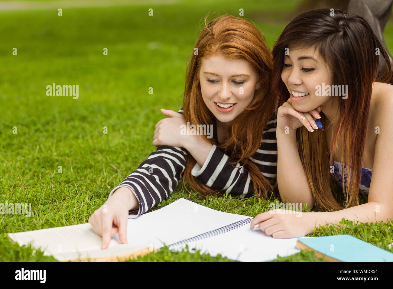 Relaxed female college students with books in the park Stock Photo - Alamy