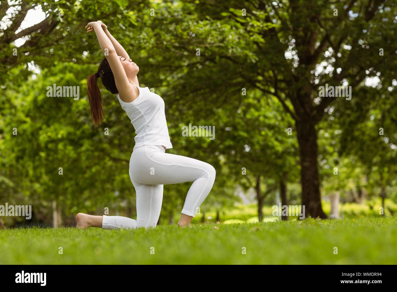 Side view of healthy and beautiful young woman doing stretching ...