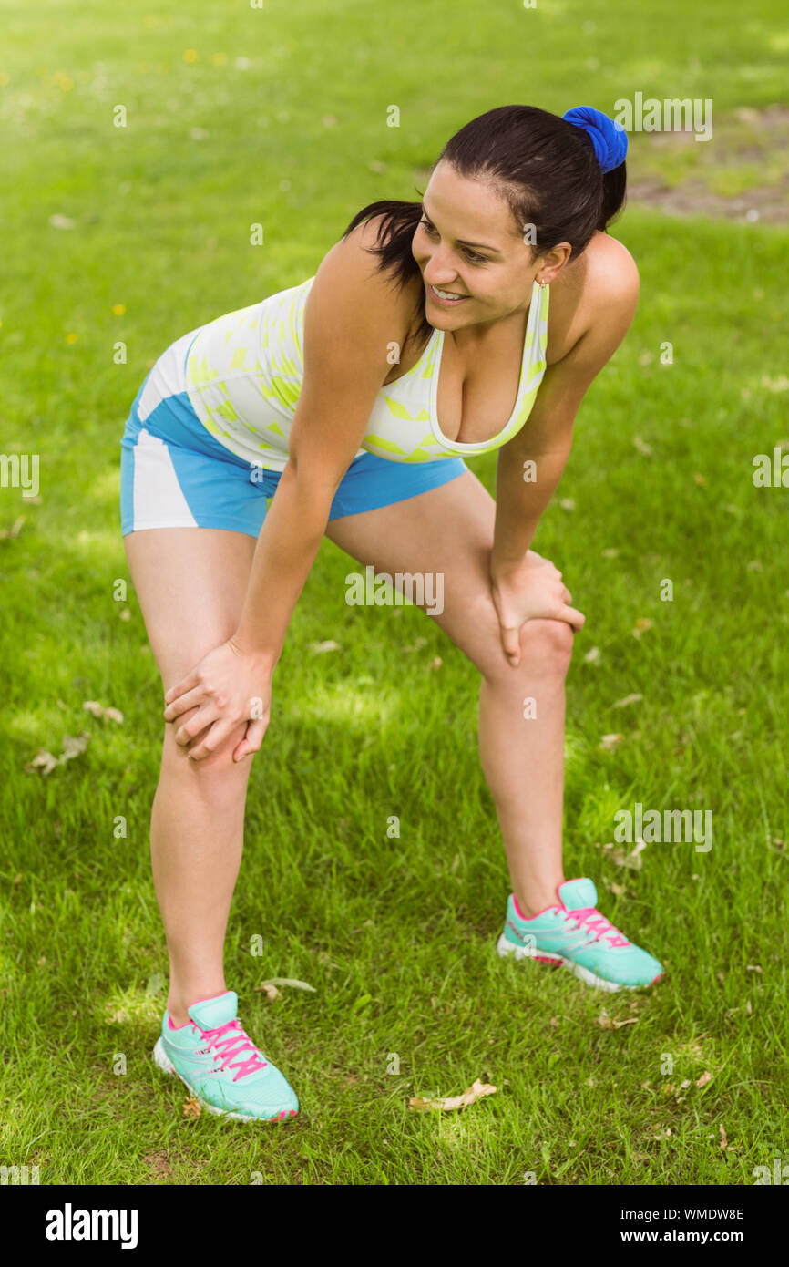 Smiling fit brunette catching her breath in the park Stock Photo