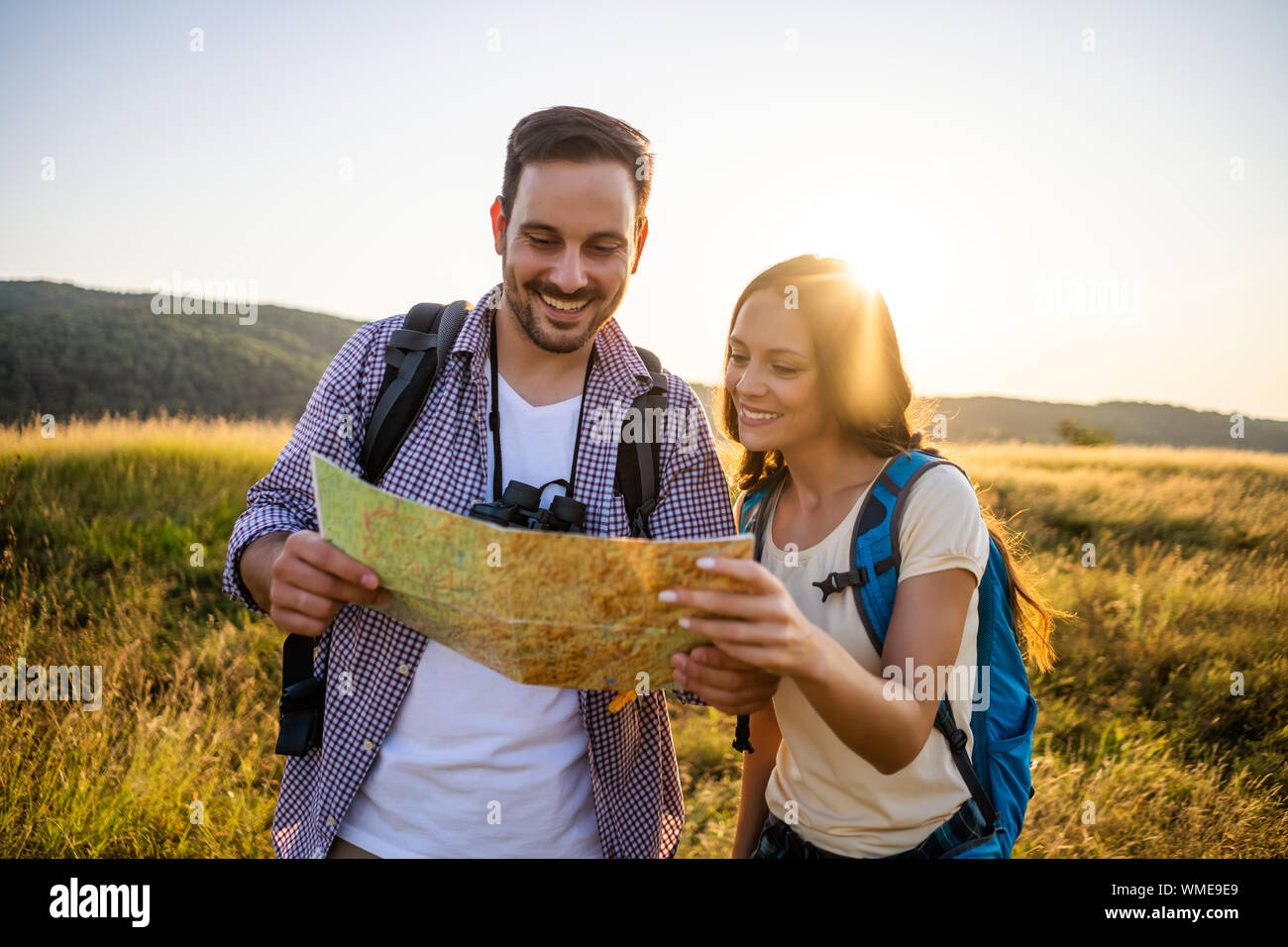 Couple is hiking in mountain. They are looking at map Stock Photo - Alamy