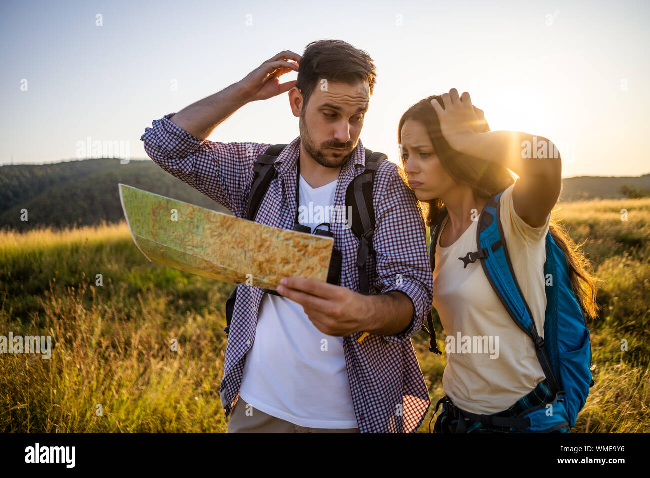 Couple is hiking in mountain. They are looking at map Stock Photo - Alamy