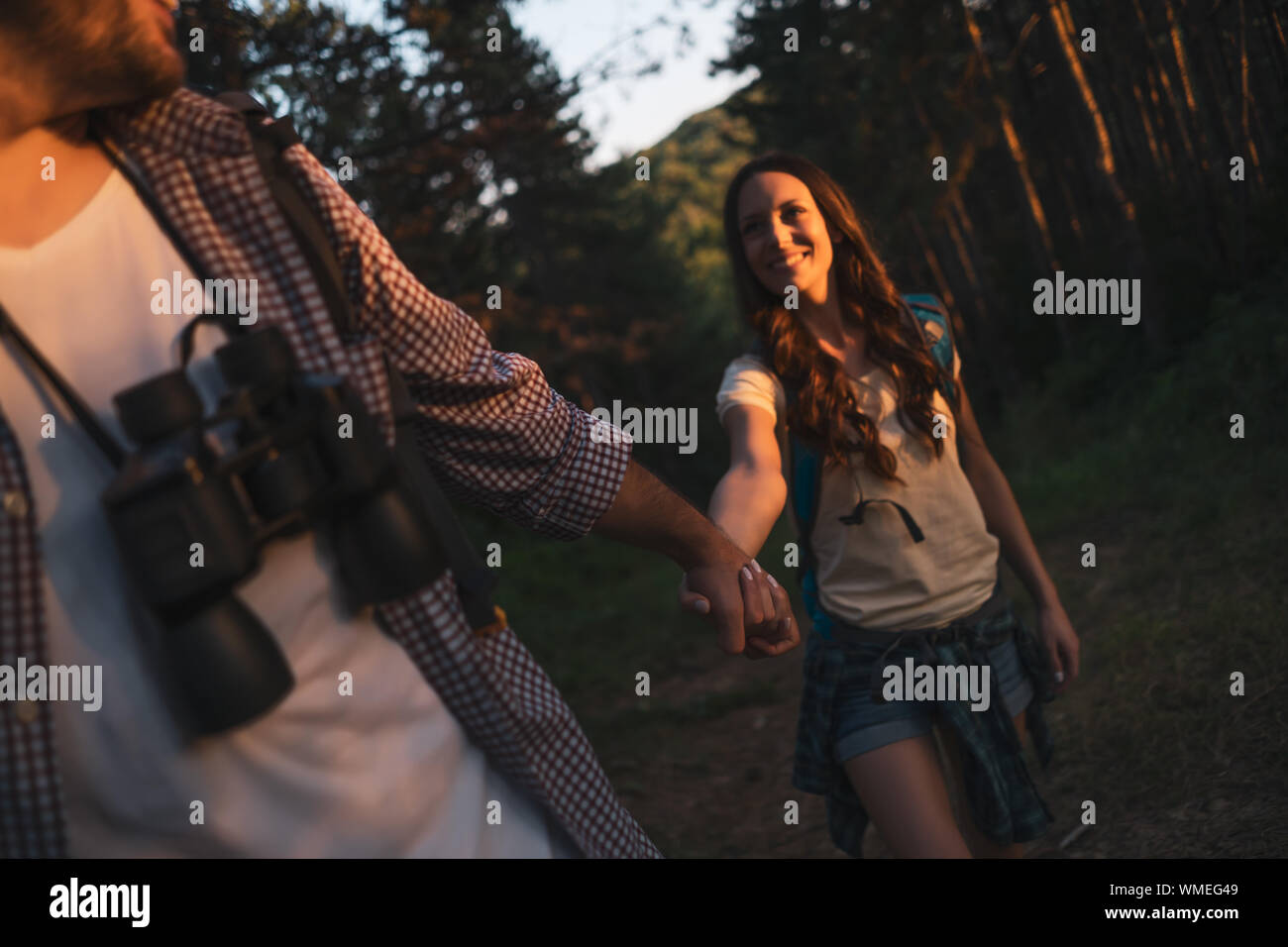 Happy couple is hiking in forest Stock Photo - Alamy