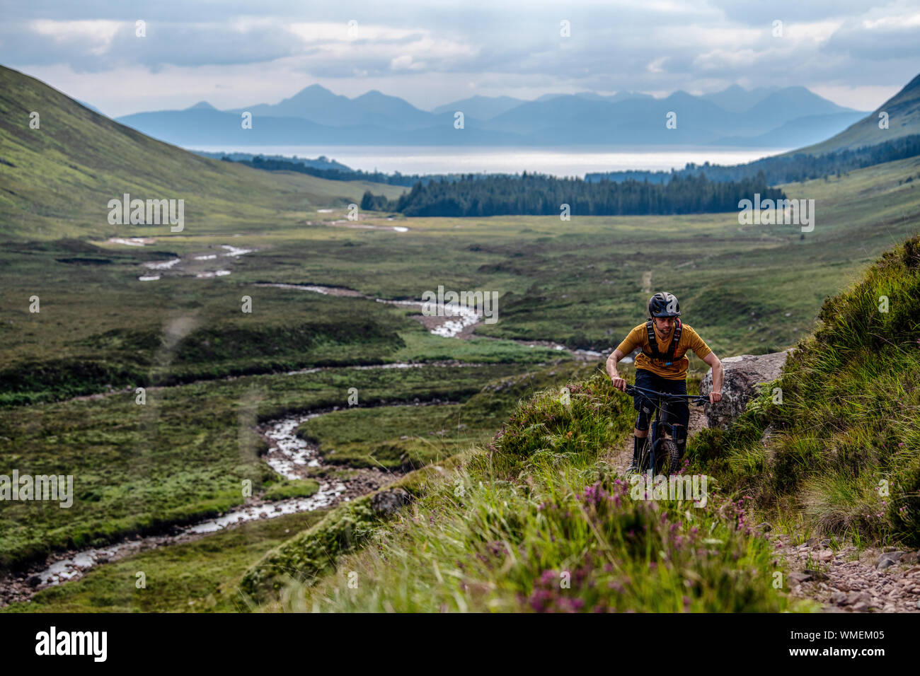 A man rides a mountain bike on a trail on the Applecross Peninsula in the north west Highlands of Scotland in the summer. Stock Photo