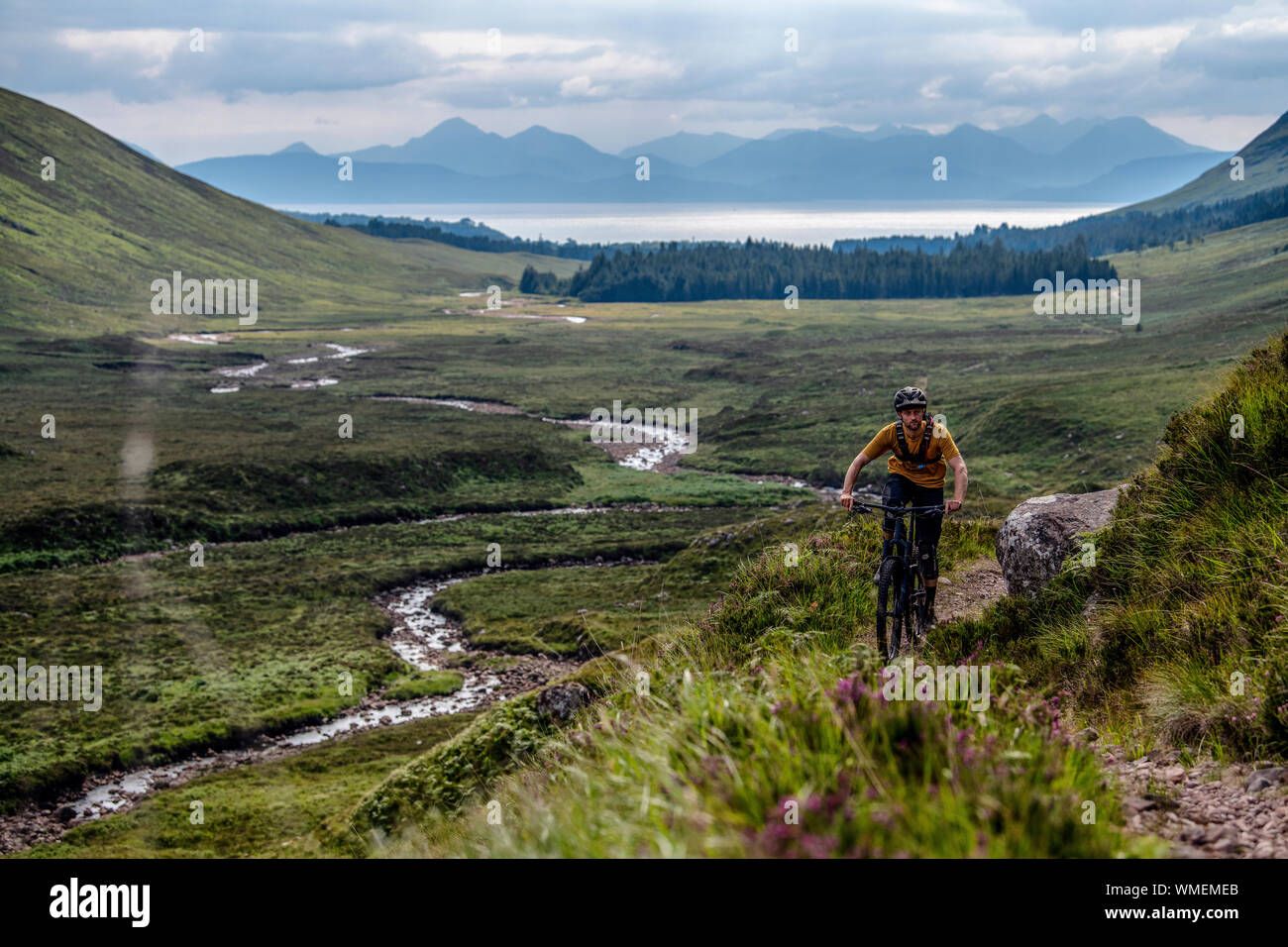 A man rides a mountain bike on a trail on the Applecross Peninsula in the north west Highlands of Scotland in the summer. Stock Photo