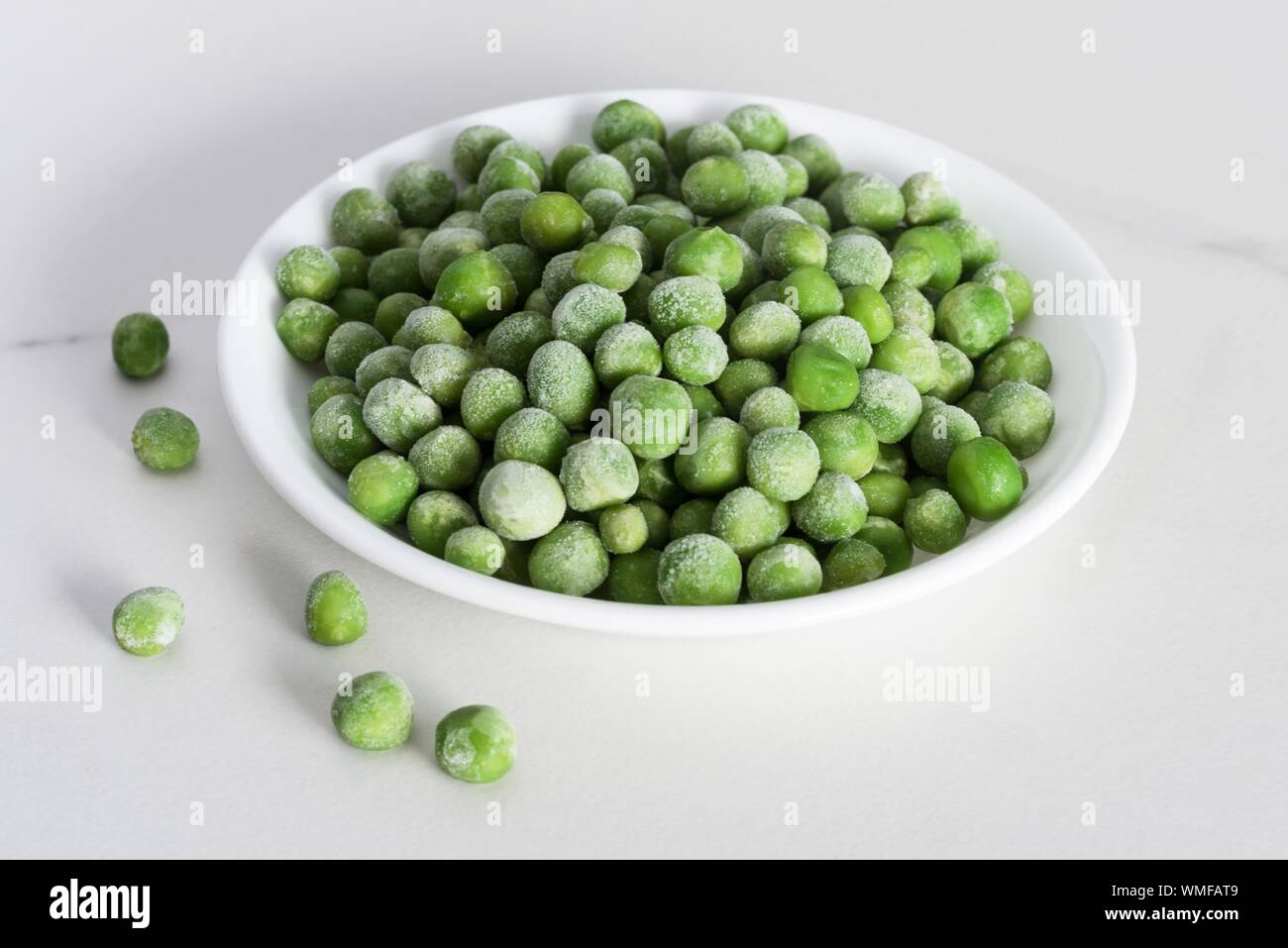 Close-up Of Green Peas In Bowl On White Background Stock Photo