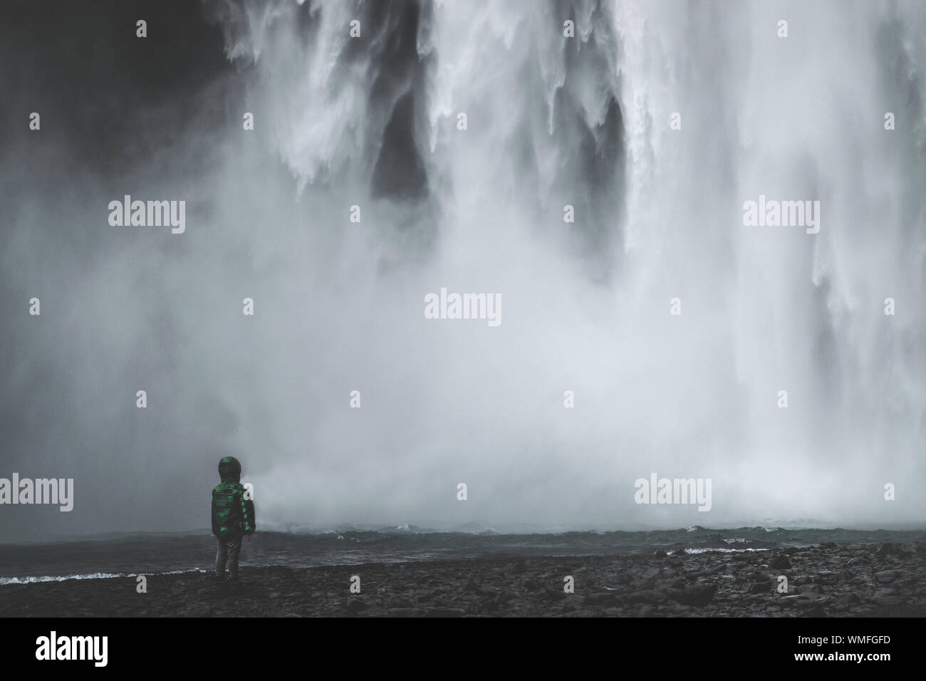 Silhouette Child Standing Against Waterfall Stock Photo