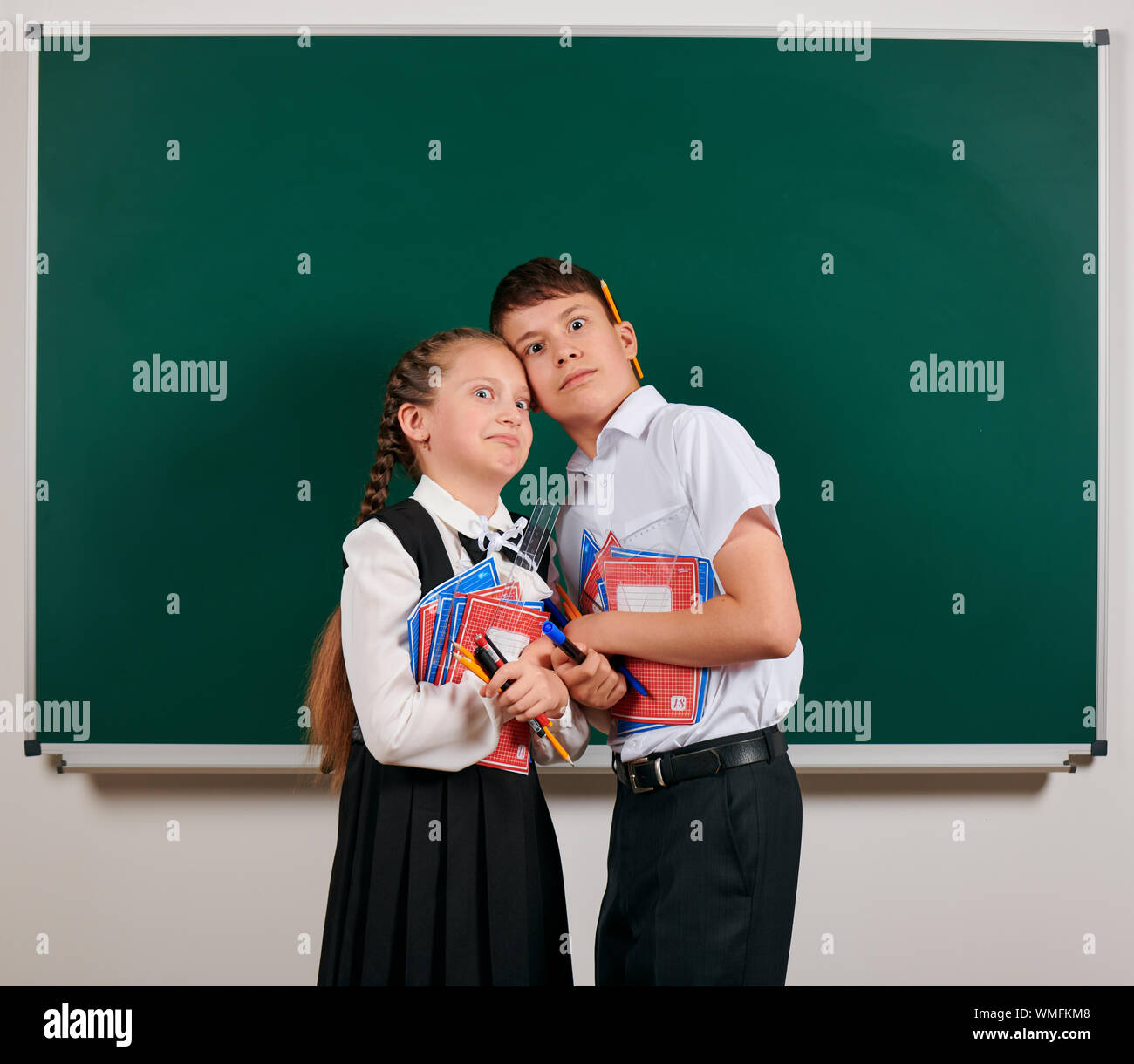 Emotional portrait of a schoolboy and schoolgirl posing with exercise ...