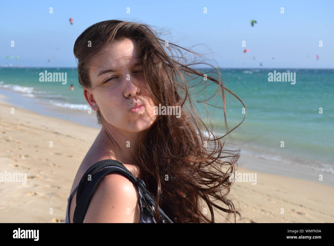 Beautiful Young Woman With Tousled Hair Puckering Lips At Beach