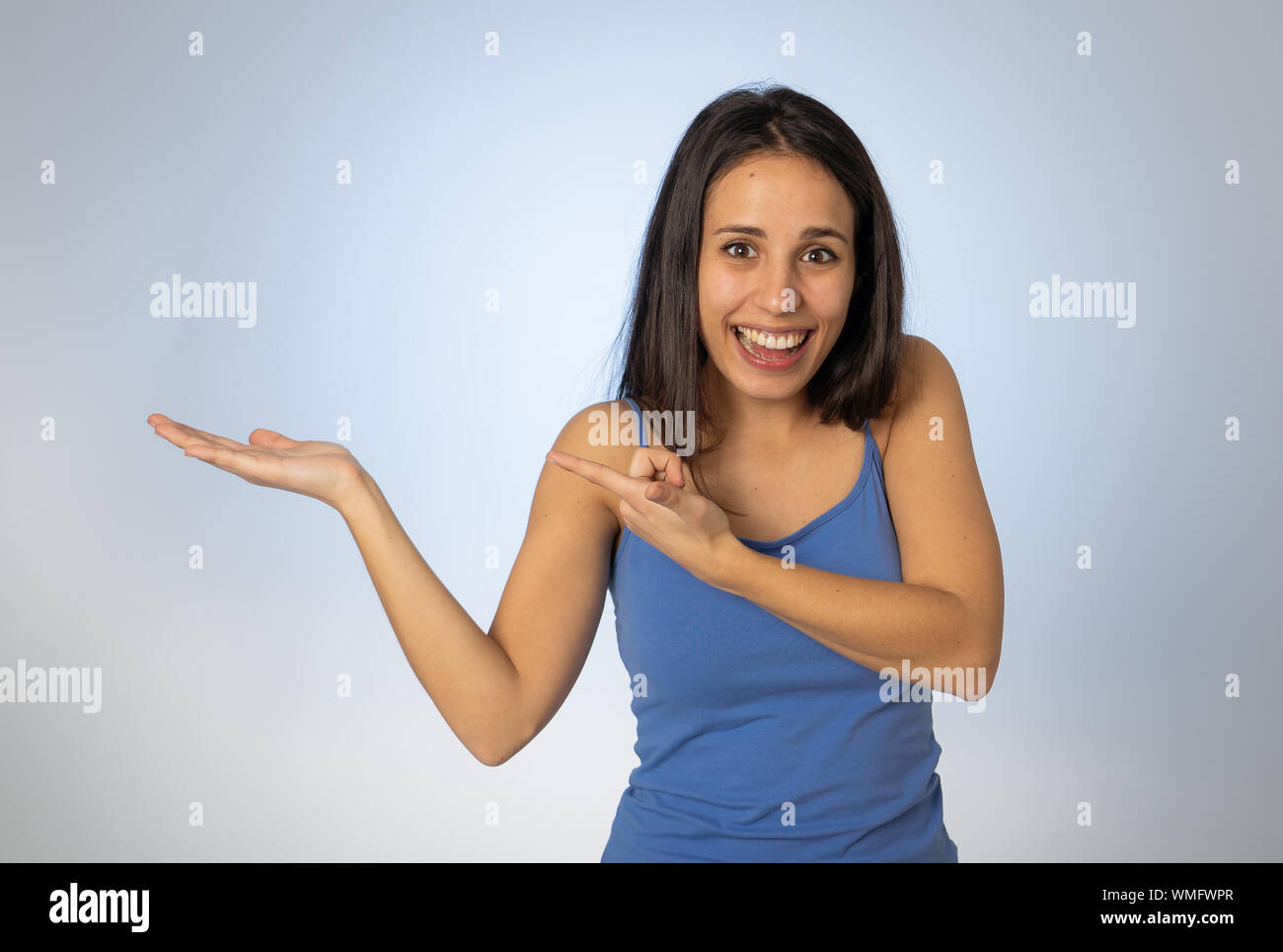 Portrait of happy young woman showing empty copy space on open hand ...