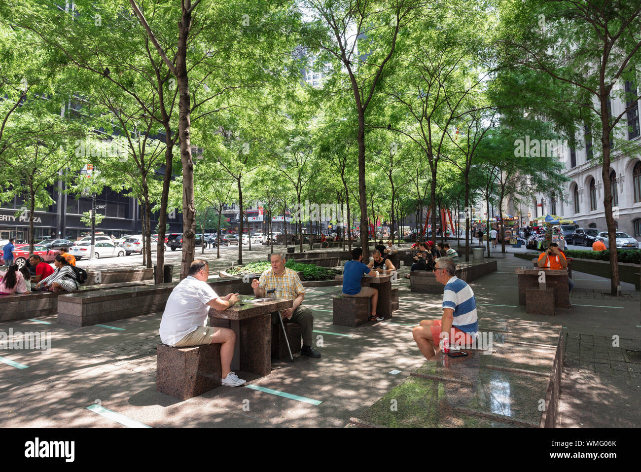 Senior men, view in summer of senior male friends socialising in Zucotti Park, Lower Manhattan, New York City, USA Stock Photo