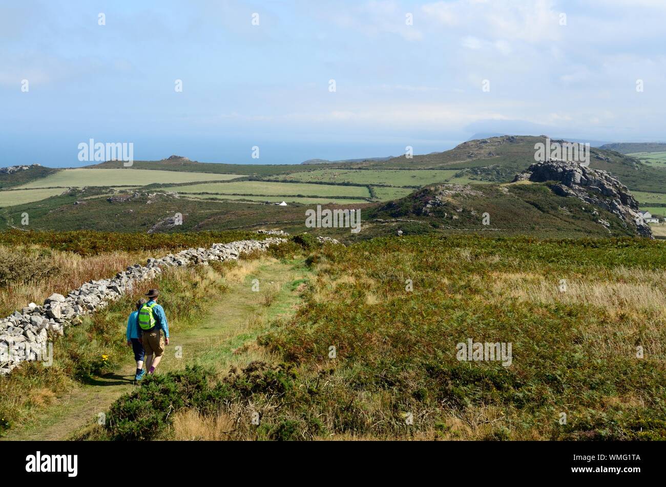 Hikers walkers walking on Garn Fawr Iron Age Fort footpath  towards Garn Fach pembrokeshire Coast National Park Wales Cymru UK Stock Photo