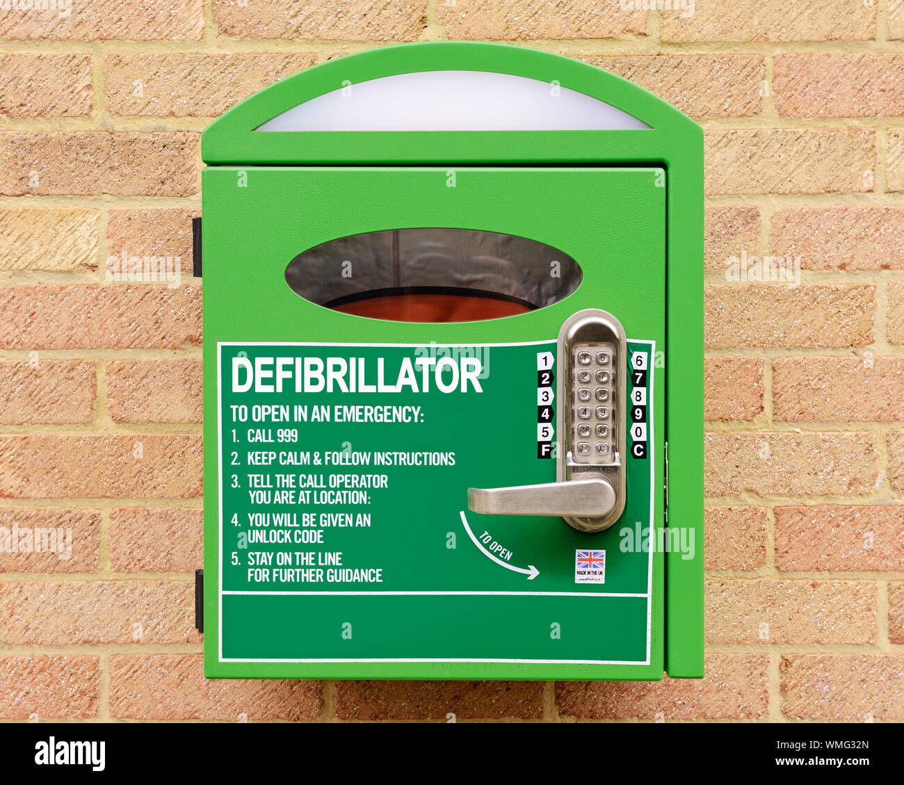 Automated External Defibrillator Mounted on the Wall of a Village Hall, Stanford in the Vale, Oxfordshire, United Kingdom Stock Photo