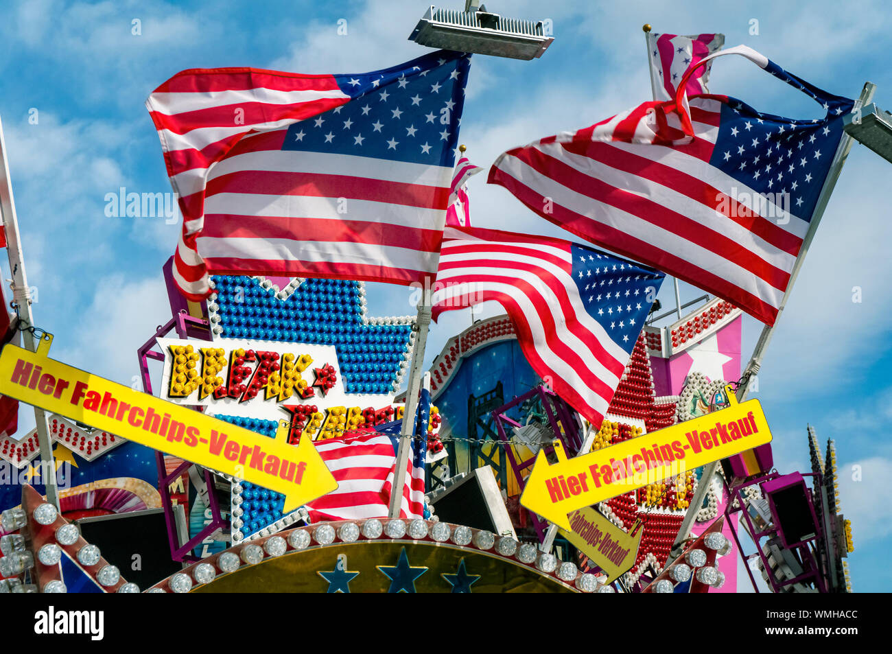 Flags of the USA at a ticket shop in front of an amusement ride on a fairground Stock Photo