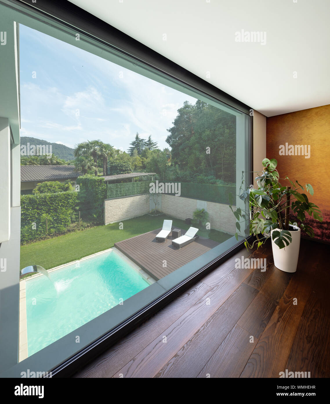 Large window in hallway of modern villa overlooking the private pool. Nobody inside Stock Photo