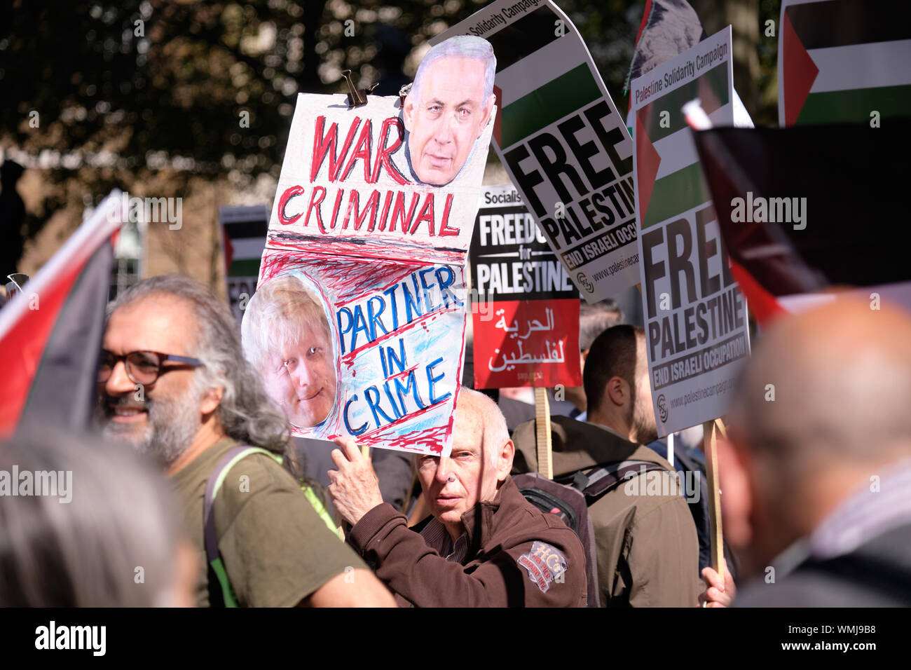 London, UK. September 5th, 2019.  Pro Palestinian supporters in London rally across 10 Downing Street to protest the visit of Israeli Prime Minister Benjamin Netanyahu.  Hundreds gatherer with signs and flags denouncing Boris Johnson and Netanyahu impromptu meeting under heavy police surveillance. Pro Palestine supporter with a War Criminal sign with Netanyahu. Credit: JF Pelletier/Alamy Live News. Stock Photo