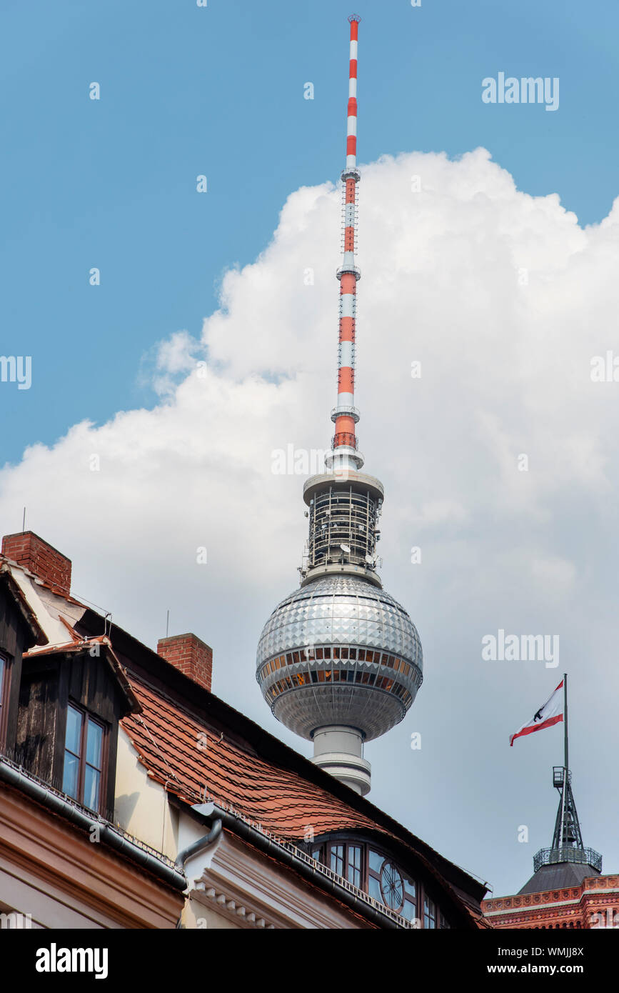 the Berliner Fernsehturm, the popular television tower of Berlin, Germany, highlighting above the tiled roofs of the houses of the Mitte district Stock Photo