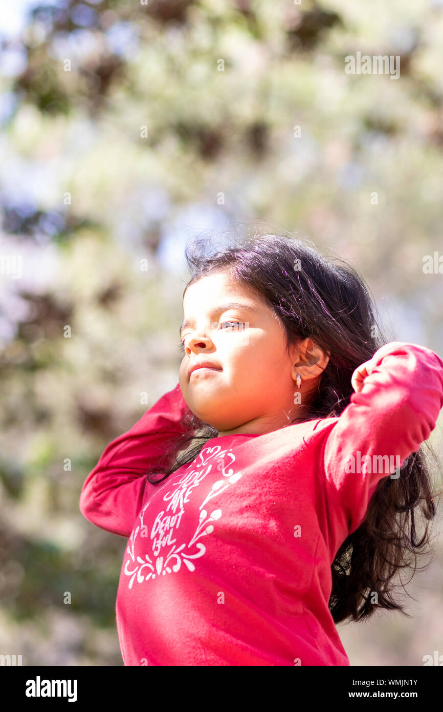 Cute girl with long black hair and red sweater Stock Photo - Alamy