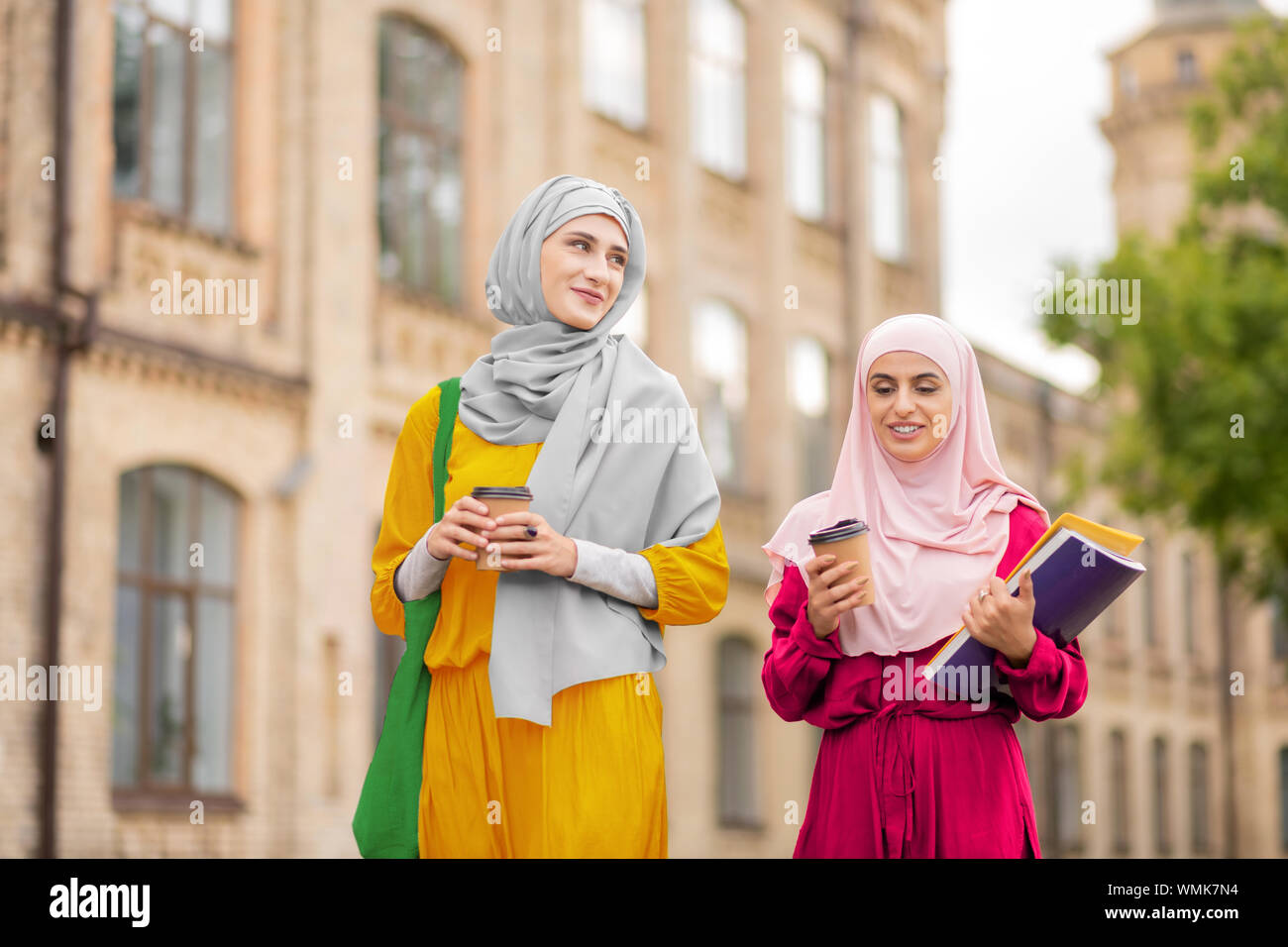 Muslim students drinking coffee and walking to university Stock Photo