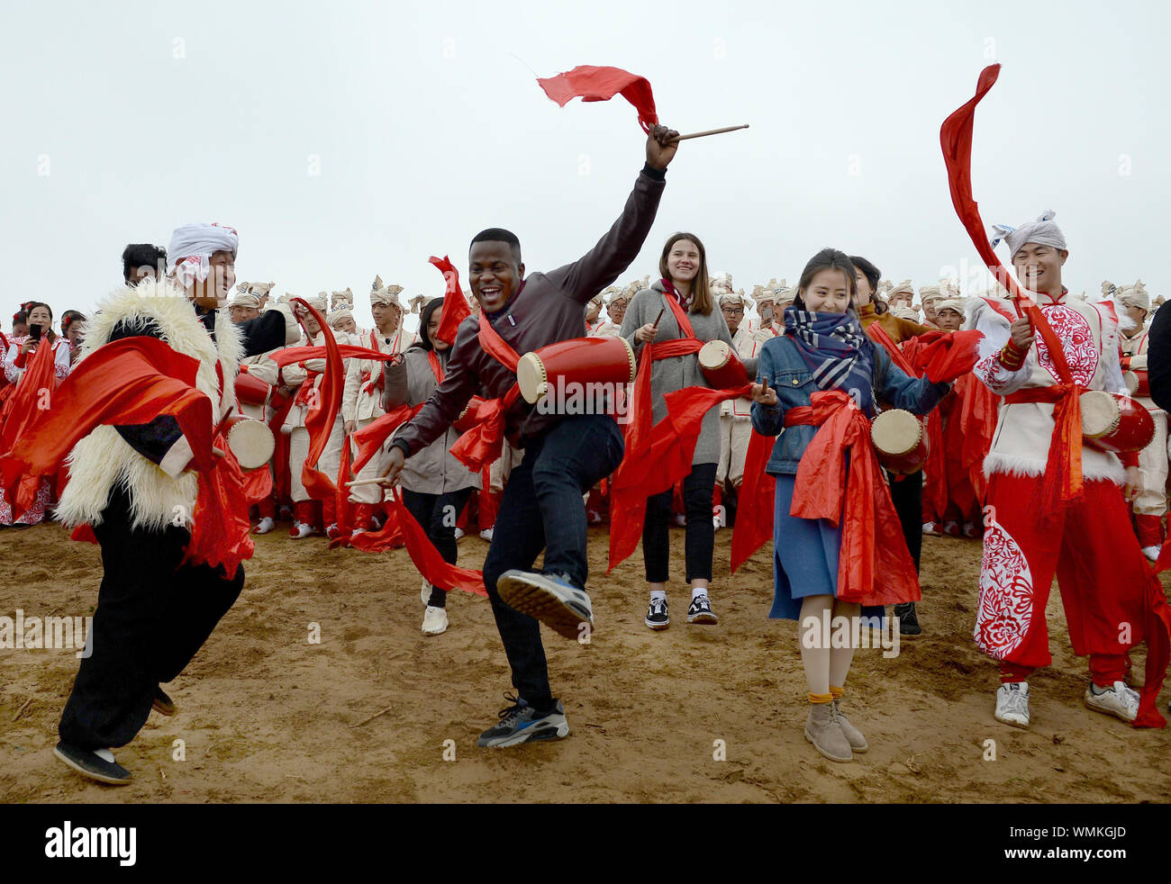 (190905) -- BEIJING, Sept. 5, 2019 (Xinhua) -- Overseas students perform Ansai waist drum dance with local dancers at Nangou Village in Ansai District of Yan'an City, northwest China's Shaanxi Province, Oct. 20, 2018. Rural revitalization strategy was first put forward during the 19th National Congress of the Communist Party of China in 2017 and repeatedly stressed by the Chinese leadership since then. The strategy's overall goal is to build rural areas with thriving businesses, pleasant living environments, social etiquette and civility, effective governance, and prosperity. (Xinhua/Liu Xiao) Stock Photo
