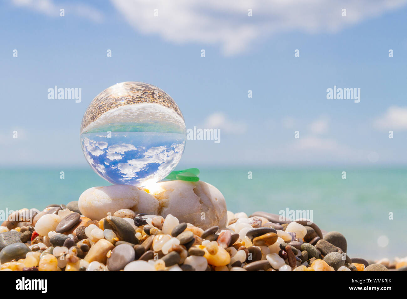 Glass round ball on the beach reflects the sea in summer Stock Photo ...