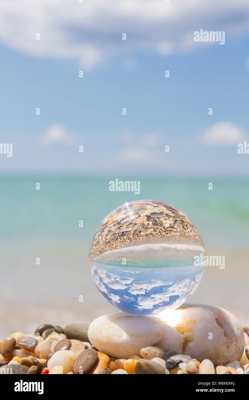 Glass round ball on the beach reflects the sea in summer Stock Photo ...