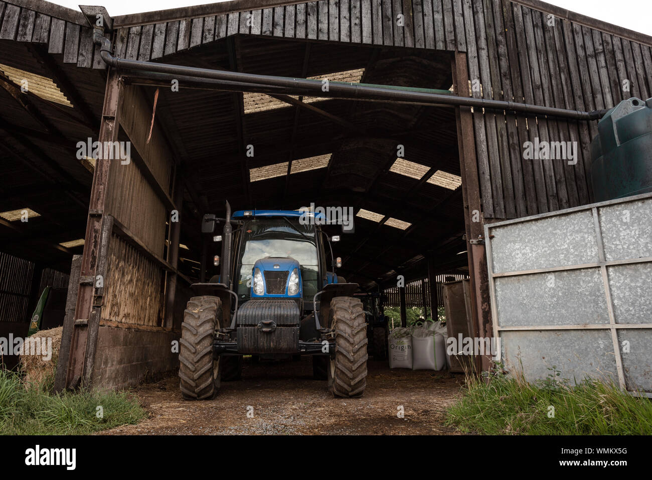 New Holland tractor in farm barn UK Stock Photo Alamy
