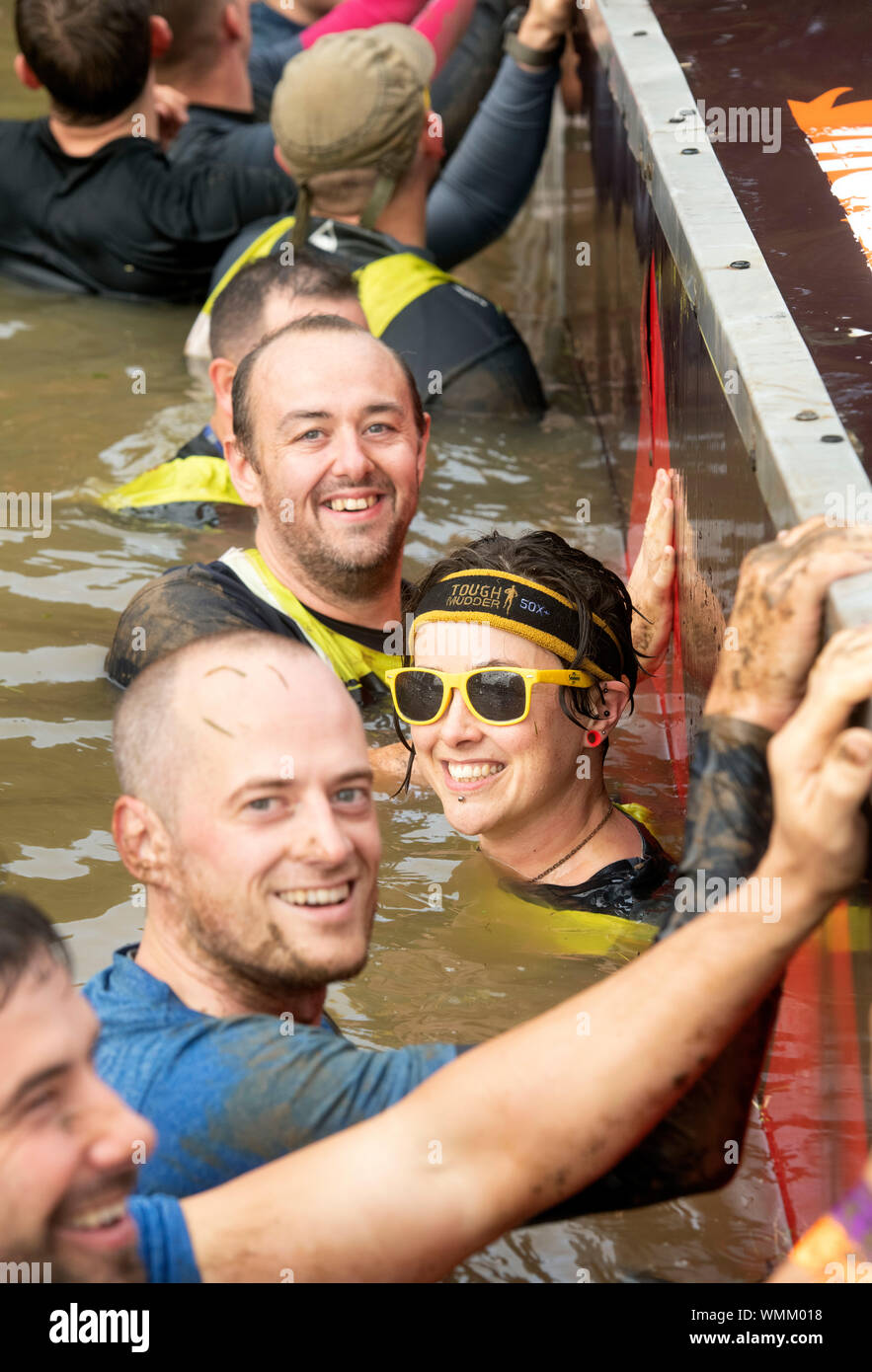 Contestants in the ‘Block Ness Monster’ obstacle at the Tough Mudder endurance event in Badminton Park, Gloucestershire UK Stock Photo
