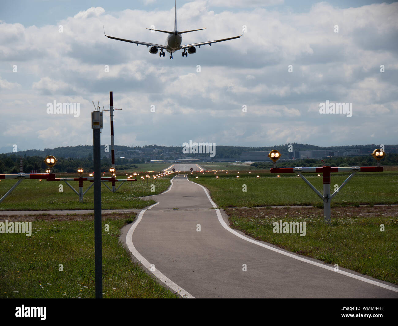 Plane landing on runway at ZRH from the end of the pist perspective Stock Photo