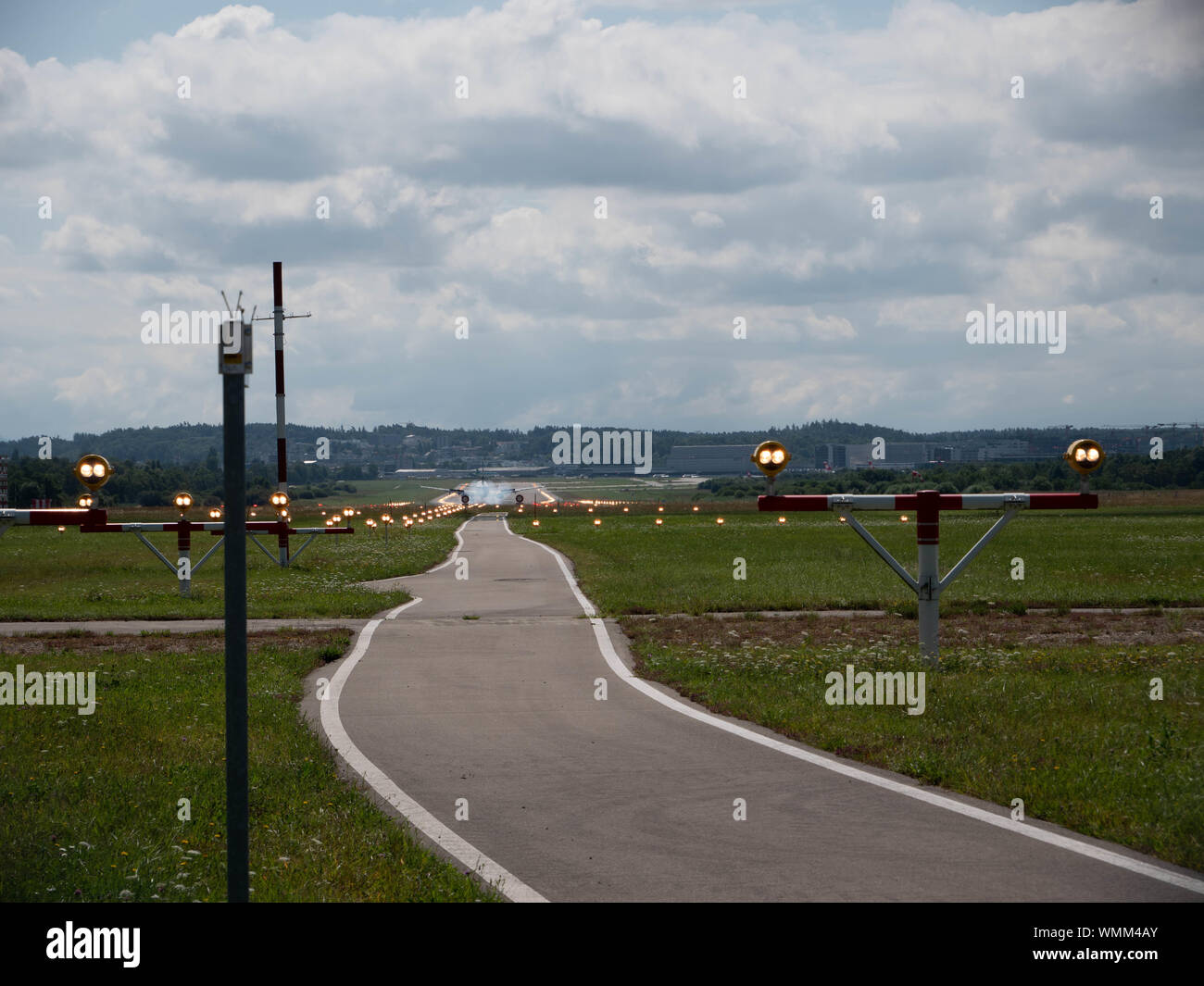 Plane landing on runway at ZRH from the end of the pist perspective Stock Photo