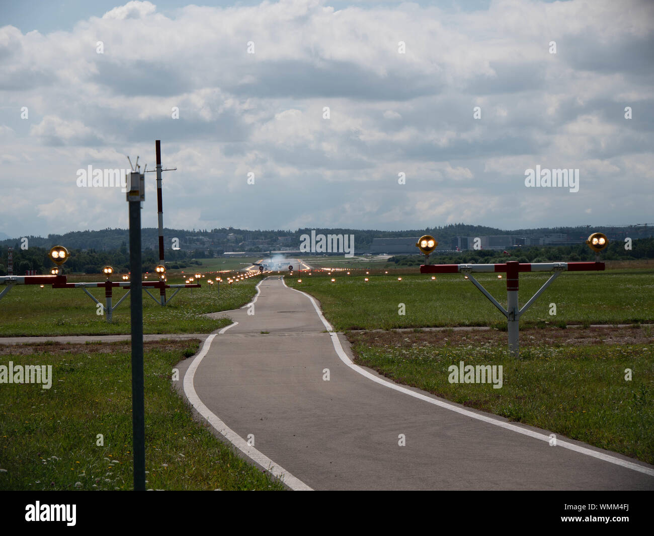 Plane landing on runway at ZRH from the end of the pist perspective Stock Photo